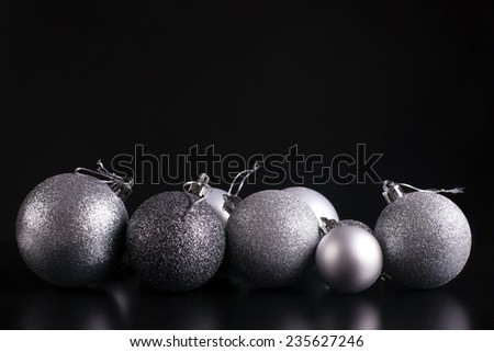 A set of stylish silver christmas decoration spheres for a christmas tree. Shiny and fashionable. On black background.