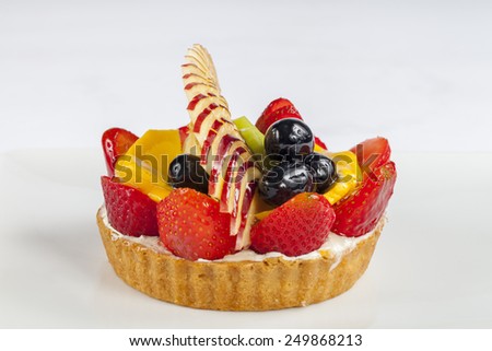 Fruit tart of strawberry, kiwi, black grape, apple and mango slices for Valentines Day isolated on white background