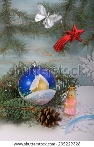 Christmas toys blue ball with painted cottage maiden star and snowflakes and fir-tree branches