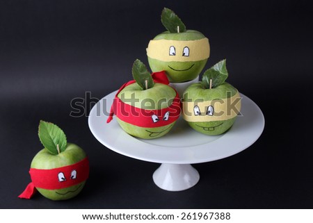 funny apples in a white vase on a black background
