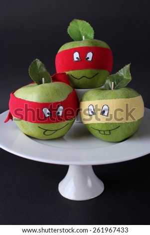 funny apples in a white vase on a black background