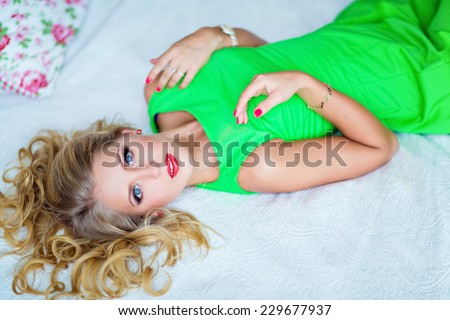Glamour portrait of beautiful young blonde girl in a green dress