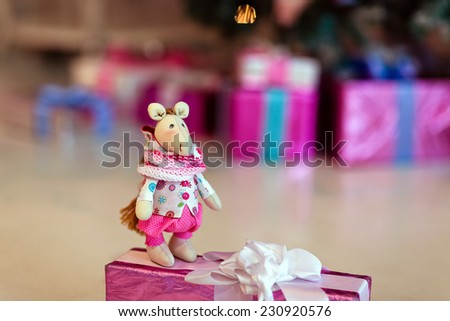 Soft toy horse on a background of Christmas gifts