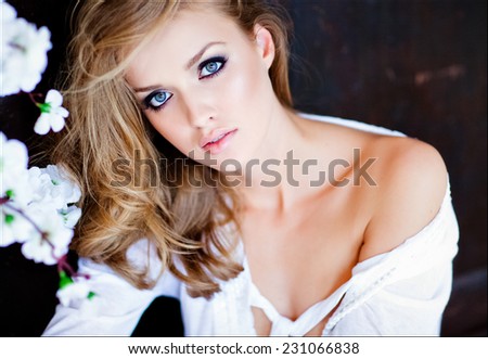 Portrait closeup sensual blonde girl with blue eyes in white shirt