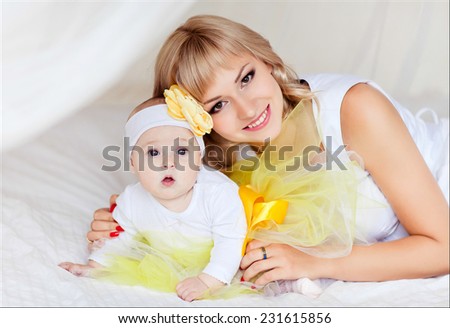 Gentle mother and daughter hugging on the bed