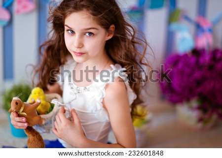 Serious cute curly haired young girl in a blue skirt, close up