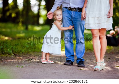 very cute little blonde girl holding the foot mom and dad