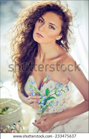 portrait of a sensual kinky girl in a white dress with flowing hair on the window background, close up