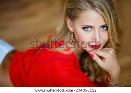 very beautiful sexy blonde girl with blue eyes in red blouse