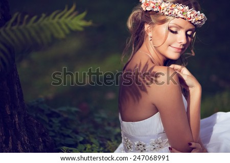 Portrait of a beautiful bride with a diadem of flowers on the head with Nude shoulders, on which falls the shadow of a fern