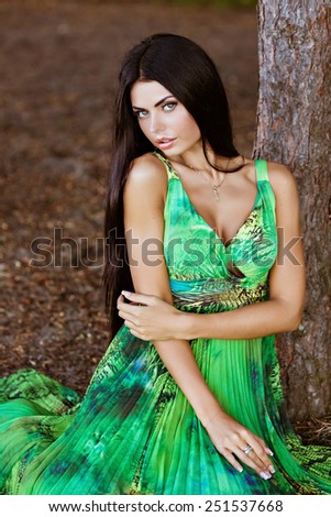 portrait of a sexy sensual very beautiful brunette girl with long hair in a green dress