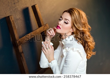Portrait of a beautiful sensual glamorous red-haired girl in a white blouse, in the Studio on a dark background, close up with my eyes closed