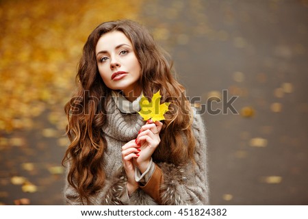 Portrait of a beautiful, dreamy and sad girl with long wavy hair in knit sweater autumn