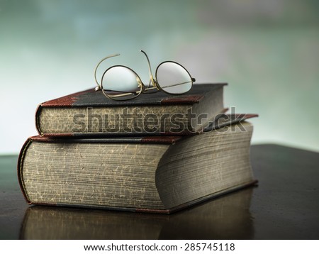 Two old books and antique reading glasses