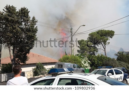 TIVON, ISRAEL - AUGUST 09: Fire erupts above the streets after a forest fire breaks out in Kiryat Tivon. Rescue workers struggle to prevent further damage. Tivon, Israel August 09, 2012