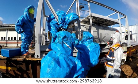 HAIFA, ISRAEL - JUNE 30, 2015: Firefighters from Northern Israel with protective gear communicate during simulation drill of leak of Bromine chemical in a container car of train.