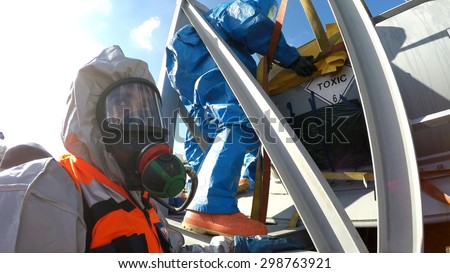 HAIFA, ISRAEL - JUNE 30, 2015: Firefighters from Northern Israel with protective gear communicate during simulation drill of leak of Bromine chemical in a container car of train.