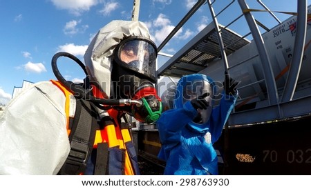 HAIFA, ISRAEL - JUNE 30, 2015: Firefighters from Northern Israel with protective gear talk with hands during simulation drill of leak of Bromine chemical in a container car of train.