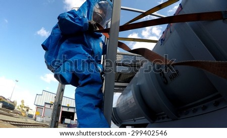 HAIFA, ISRAEL - JUNE 30, 2015: Firefighter from Northern Israel with protective gear pulls a cable during simulation drill of leak of Bromine chemical in a container car of train