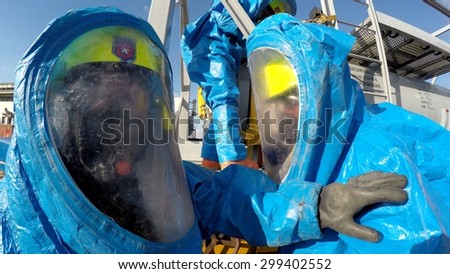 HAIFA, ISRAEL - JUNE 30, 2015: Firefighters from Northern Israel with protective gear communicate during simulation drill of leak of Bromine chemical in a container car of train