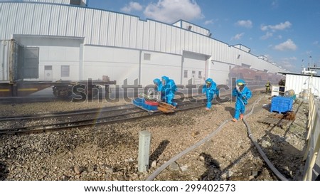 HAIFA, ISRAEL - JUNE 30, 2015: Firefighters from Northern Israel with protective gear approach disaster zone during simulation drill of leak of Bromine chemical in a container car of train