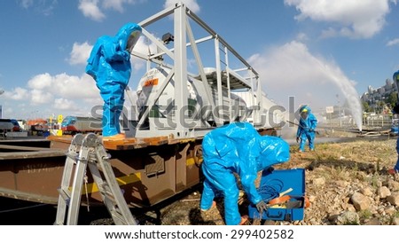 HAIFA, ISRAEL - JUNE 30, 2015: Firefighter from Northern Israel with protective gear opens tool box during simulation drill of leak of Bromine chemical in a container car of train