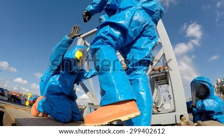 HAIFA, ISRAEL - JUNE 30, 2015: Firefighters from Northern Israel with protective gear resolve a problem during simulation drill of leak of Bromine chemical in a container car of train