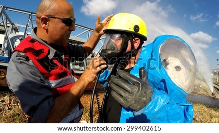 HAIFA, ISRAEL - JUNE 30, 2015: Firefighters from Northern Israel with protective gear put oxygen mask during simulation drill of leak of Bromine chemical in a container car of train