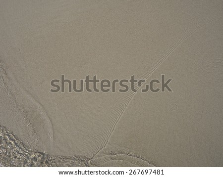 Clear and bright ripple sea water on sand beach. Image is filtered.