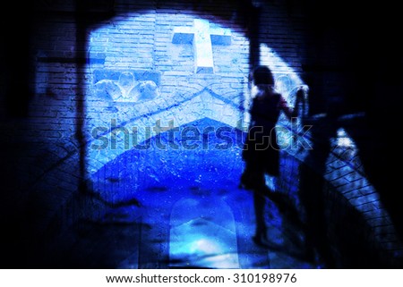 The silhouette of a woman in a black alley (blurred background, double exposure)