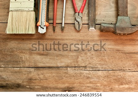 Brush cutter, screwdriver, hammer, chisel is placed on a wooden table