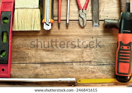 Brush cutter, screwdriver, hammer, chisel is placed on a wooden table