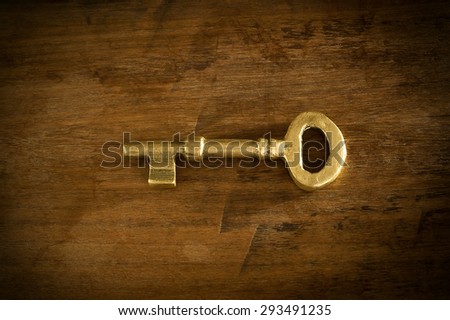 Old brass keys placed on a wooden floor low key light.