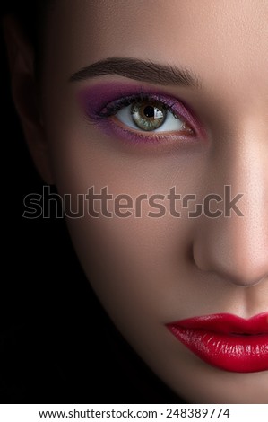 Half face of beautiful girl with stylish make-up creative eye smoke eye bright colors with beautiful red lips