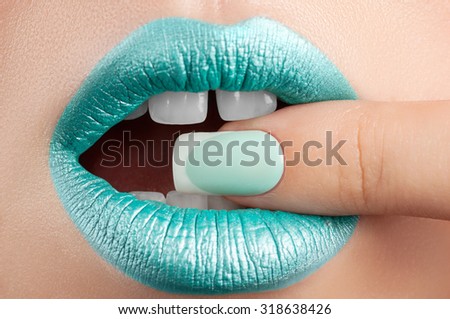 Turquoise lip gloss and a beautiful nails.