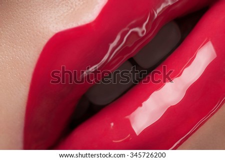 Red shine on natural lips close up.