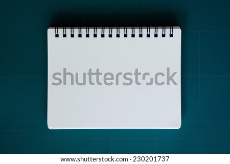notebook on blue cutting mat
