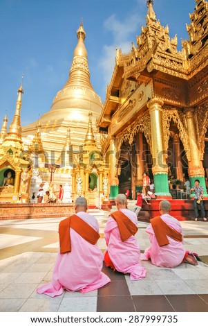YANGON, MYANMAR - APRIL 13, 2012 : Three Burmese Buddhist nuns at the Shwedagon Pagoda, one of the most famous pagoda in the world and the main attraction of Yangon, Myanmar.