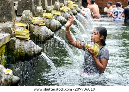 BALI, INDONESIA - JANUARY 17: Worshippers make an offering at the Tirta Empul Temple on January 17, 2013 in Bali, Indonesia. They believe that water from the spring is holy and has the healing power.
