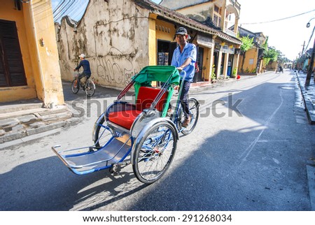 HOI AN, VIETNAM - OCTOBER 24, 2012 : Unidentified man riding a traditional cyclo in Hoi An, Vietnam