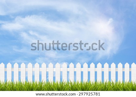 fresh green grass and white wooden fence under blue sky ,clouds and sunlight of summer background