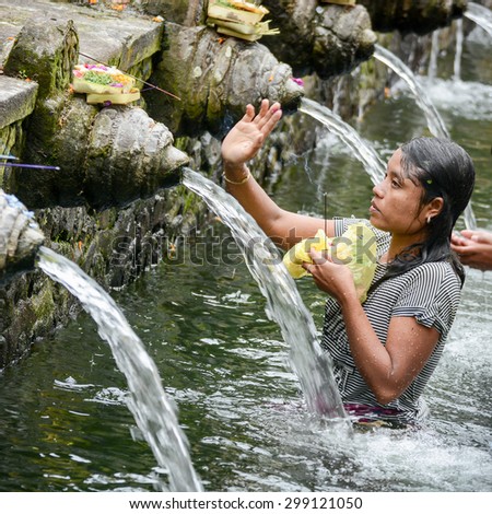 BALI, INDONESIA - JANUARY 17: Worshippers make an offering at the Tirta Empul Temple on January 17, 2013 in Bali, Indonesia. They believe that water from the spring is holy and has the healing power.