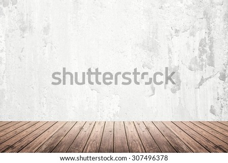 Empty room of old grunge cracked white concrete wall and dark brown wooden floor with light on top