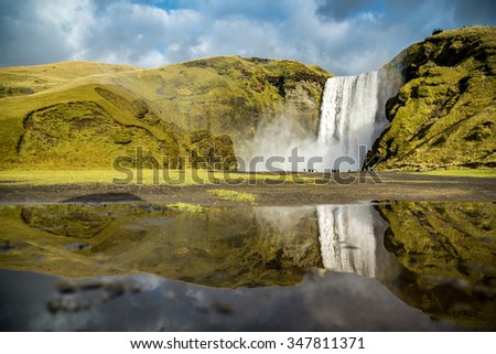 Reflection of Skogafoss, beautiful and powerful waterfall. This place is a famous natural landmark of Southern Iceland