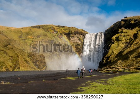 Tourists visit Skogafoss, beautiful and powerful waterfall. This place is a famous natural landmark of Southern Iceland