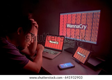 WannaCry ransomware attack on desktop screen, notebook and smartphone, internet cyber attack with Anonymous calling on smart phone to get the ransoms payment to decrypt the code