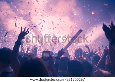 Silhouette hands of audience crowd people use smart phones enjoying the club party with concert.  Celebrate new year party , Blurry night club DJ party people enjoy of music dancing sound .
