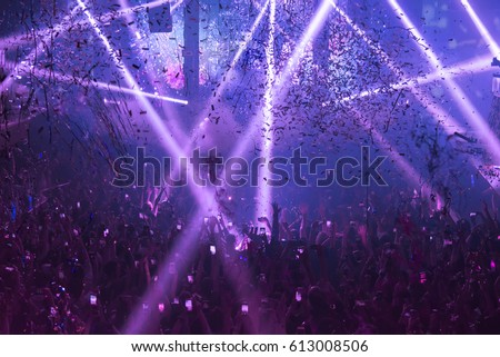 Light Show And Silhouette hands of audience crowd people use smart phones enjoying the club party with concert.  Blurry night club DJ party people enjoy of music dancing sound .