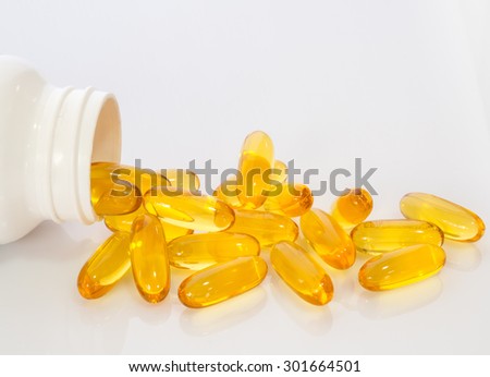Omega 3 fish oil capsules out open container on white background
