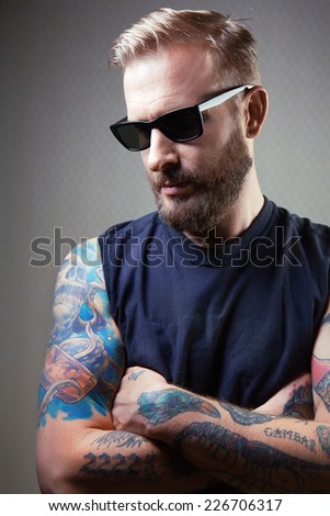Portrait of a handsome brutal man with tattoos. tattoos